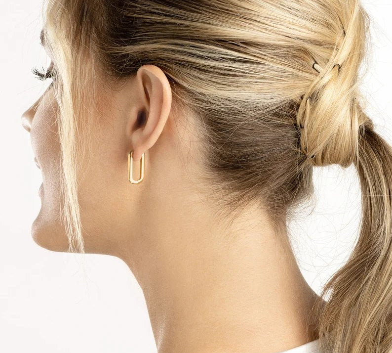 Close-up of chunky 14k gold paperclip hoop earrings with latch back closure